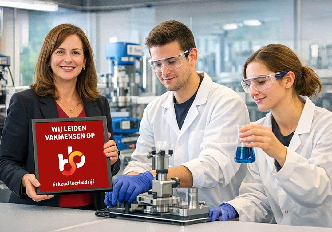 Frau in Business-Anzug hält ein Schild im Labor, während zwei Laboranten mit wissenschaftlichen Geräten und blauer Flüssigkeit experimentieren; Rodanco, SBB-Akkreditierung als Praktikumsunternehmen erneuert.