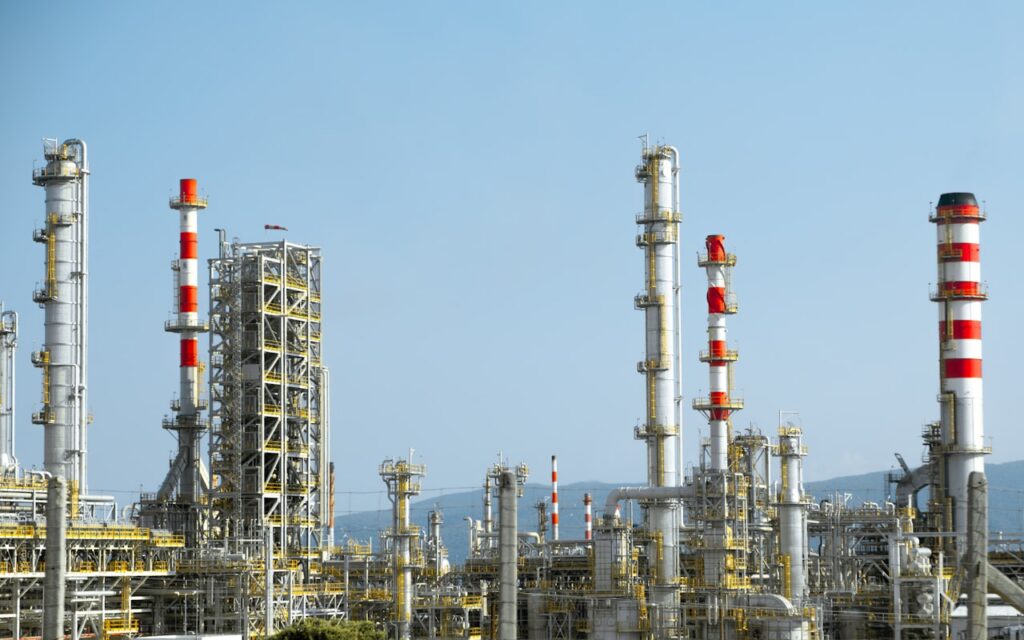 Industrial pipes and pressure vessels in an oil production facility showing scale formation risk