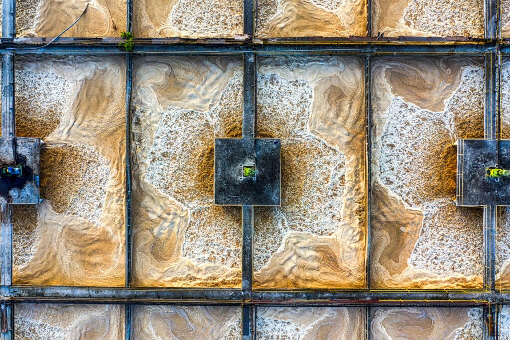 Aerial view of water treatment basins with flocculated material on the surface