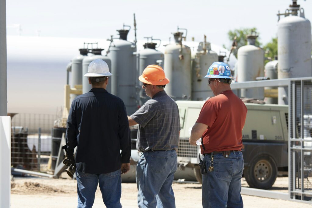 Engineers in hard hats discussing process equipment on site