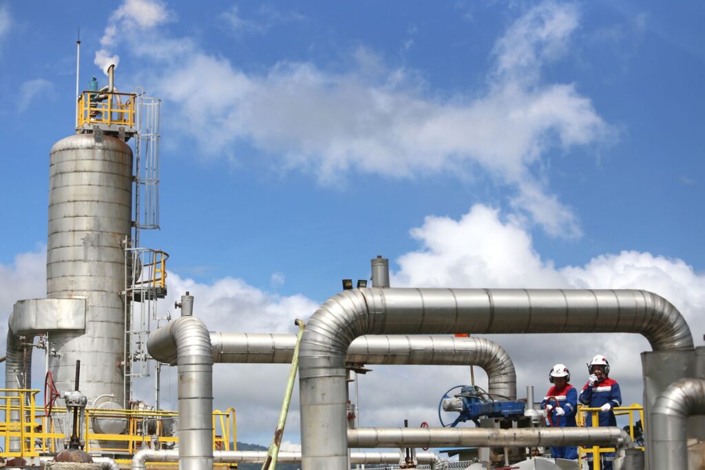 Oil and gas processing plant with a vertical vessel and pipework, engineers on site