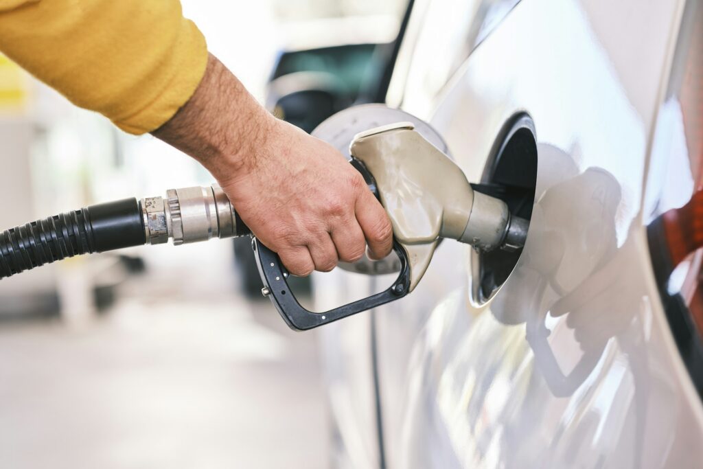 Fuel nozzle in a car filler neck at a petrol station, where Stage 2 vapour recovery applies