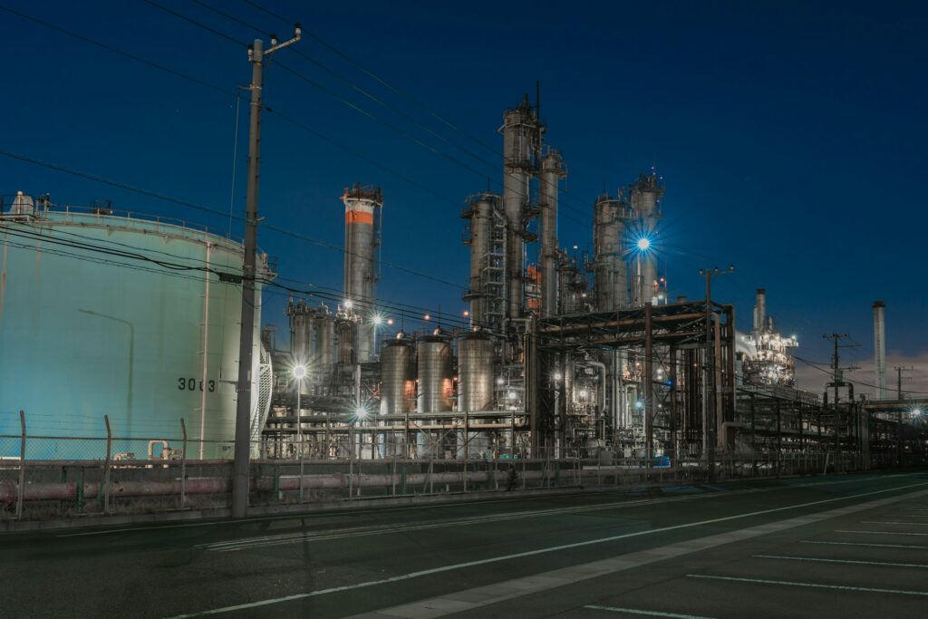 Process plant with a storage tank and columns at dusk, where vapor recovery towers and VRUs work side by side