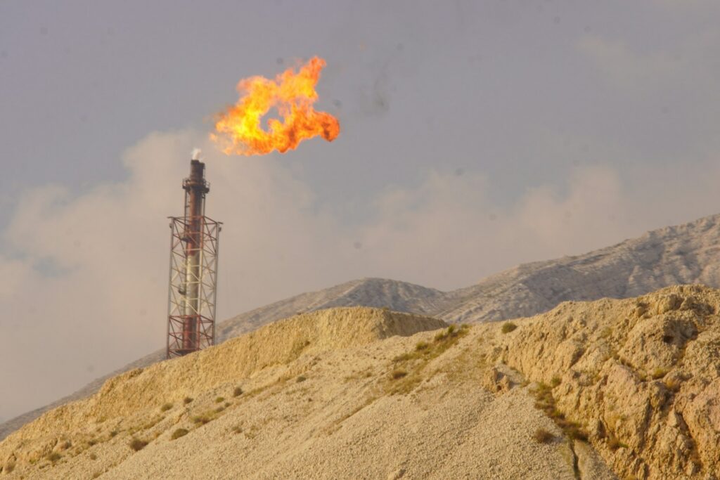 Gas flare burning at an industrial site, the kind of emission source a VRU helps reduce